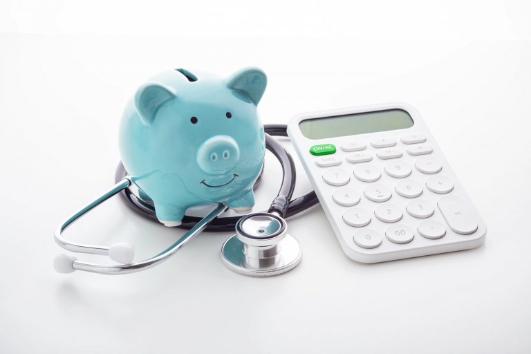 Piggy bank with stethoscope and calculator