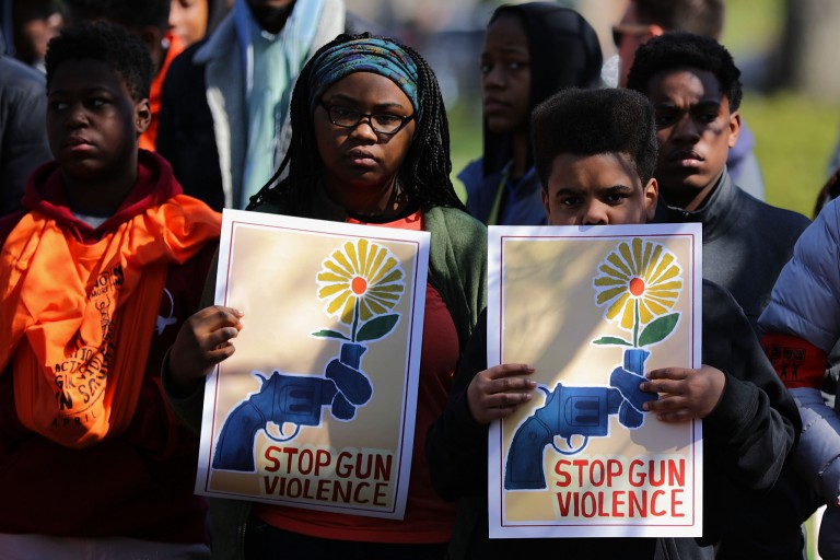 Two children hold signs that read "stop gun violence"