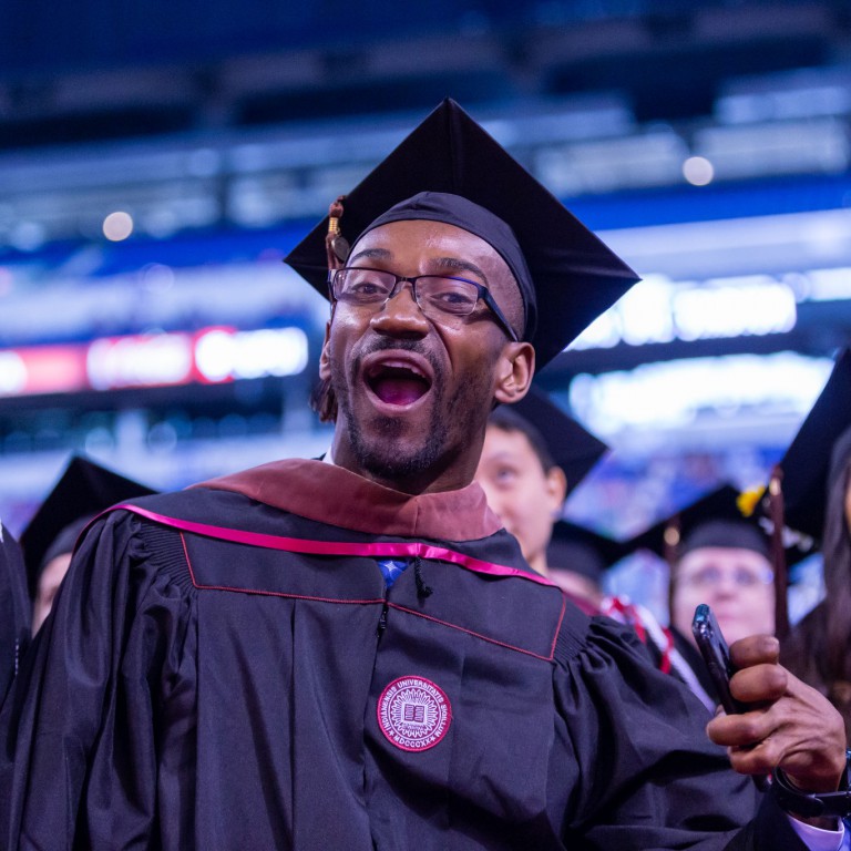 Graduate Johnson Simon celebrates at Commencement.