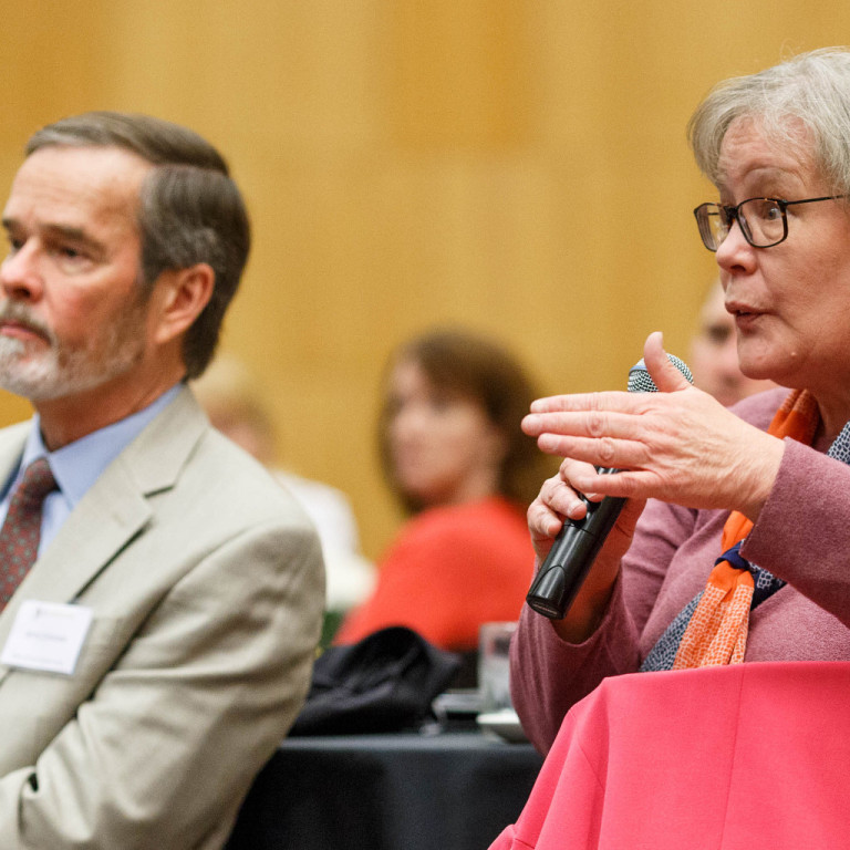 A female attendee at the 2017 E2E Convergence poses a question to the keynote speaker.