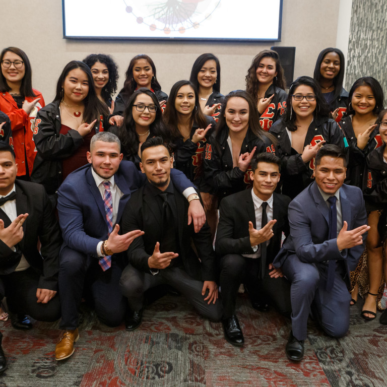 Members of two culturally based organizations pose for a photo at the installation.