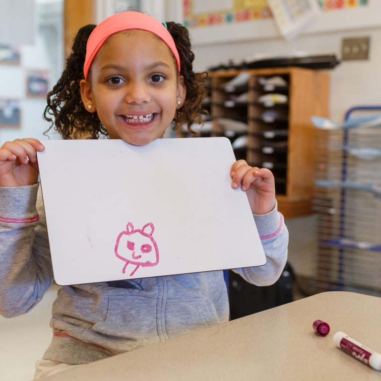 A girl shows a drawing