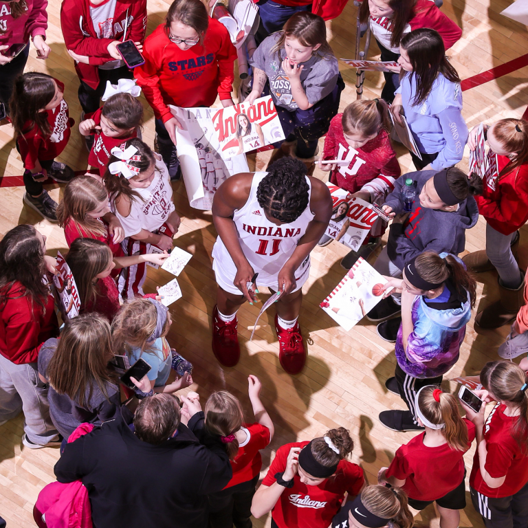 An IU women's basketball player signs autographs for fans