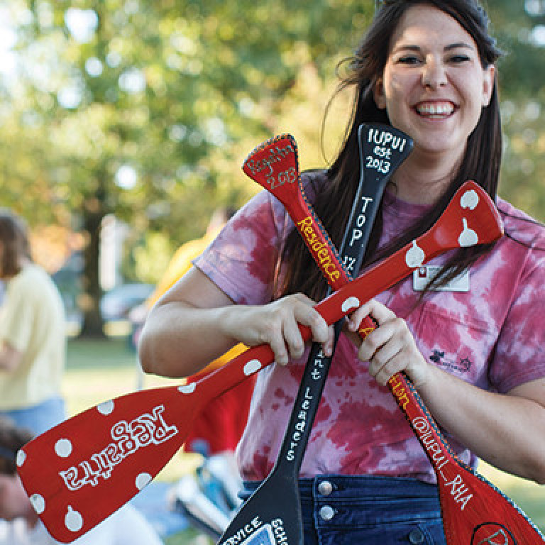 A student showcases the painted oars during the annual S'mores N' Oars event.