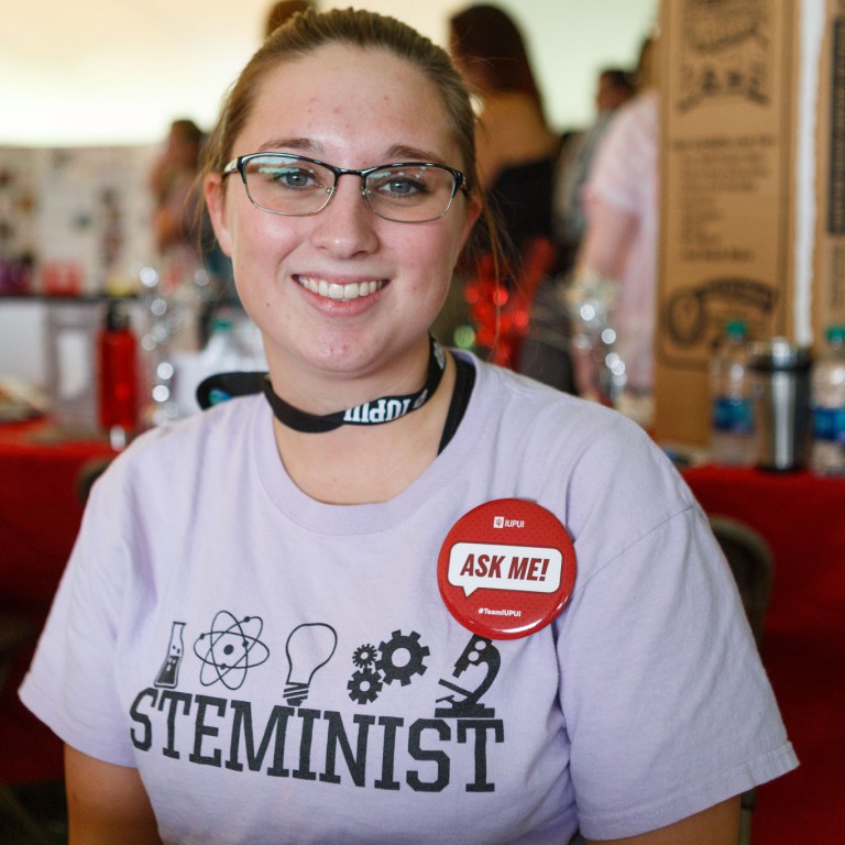 An IUPUI student works the Fall Involvement Expo wearing a STEMINIST T-shirt.