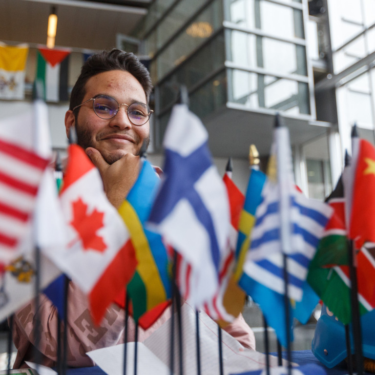 An exhibitor sits behind a collection of mini-flags at the 2020 IUPUI International Festival.
