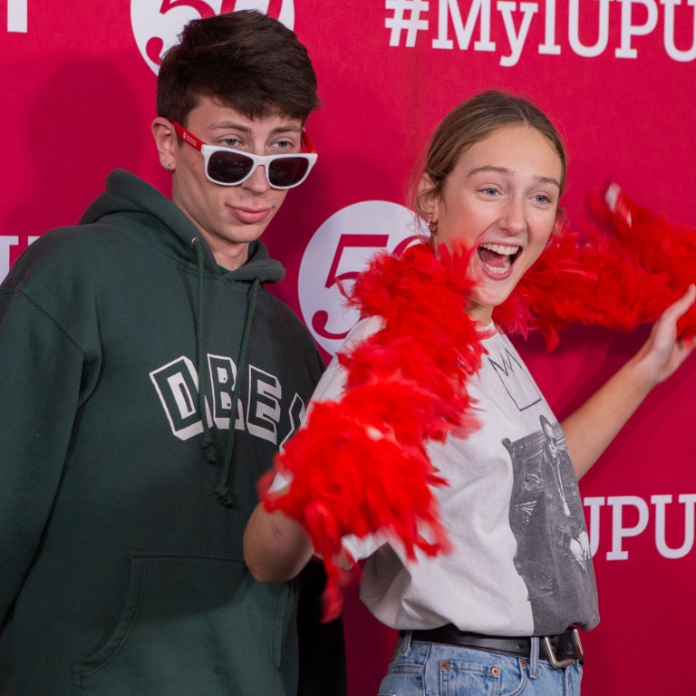 Students pose for a photo using funny props in a photo booth