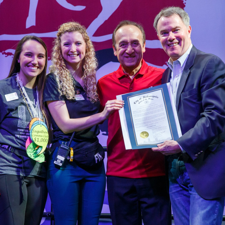 Two IUPUI students, chancellor Paydar and Indianapolis mayor Joe Hogsett pose with a proclamation