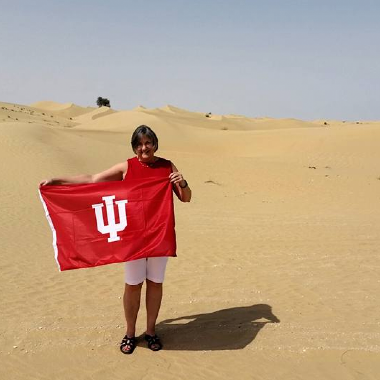 Woman standing in the dessert with an IU flag