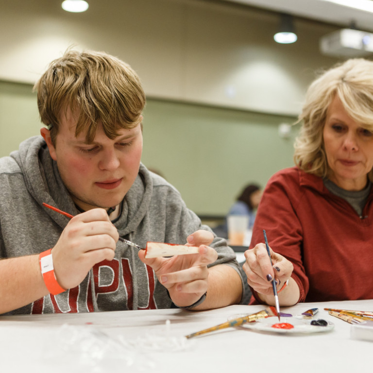 A family paints an object at SAPB's JagFest.