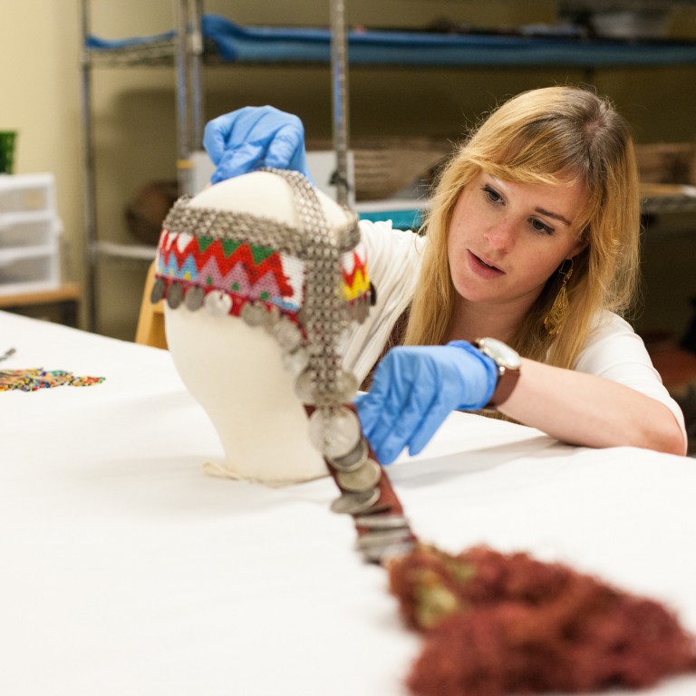 Maggie Slaughter dresses a bust with a dorsal plate used as a ceremonial headdress in Syrian culture