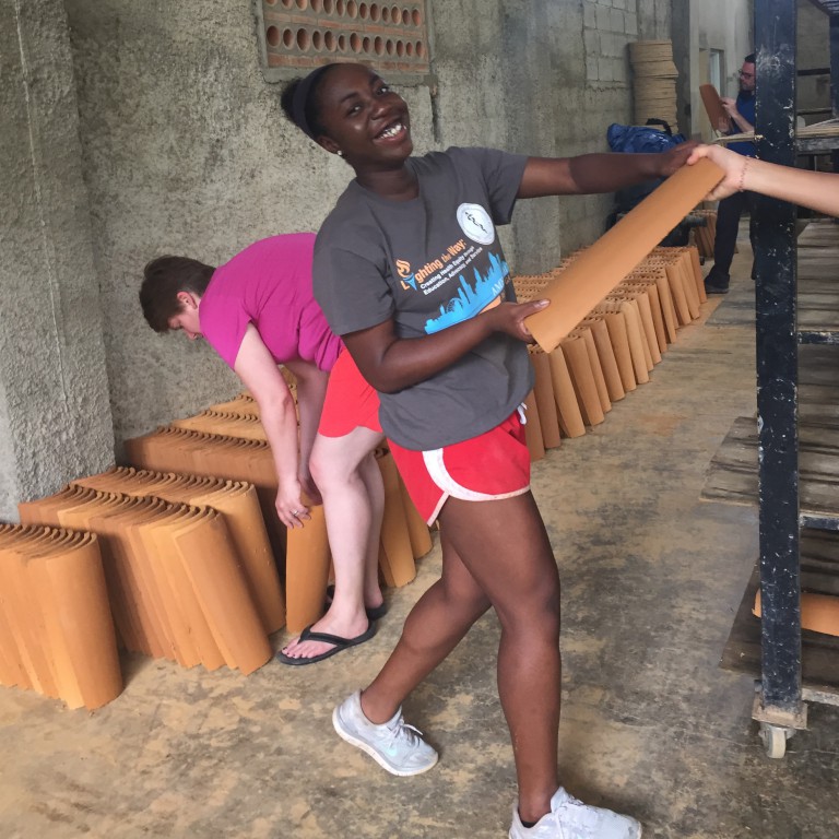 Fola Alade helps move tiles in the factory.