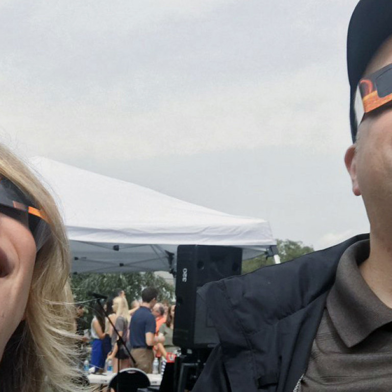 Two people take a selfie while viewing the eclipse