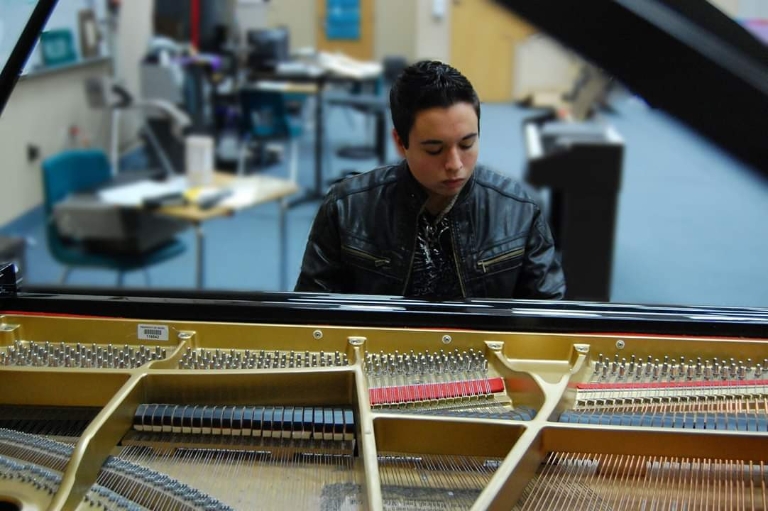 Dominic Muzzi sits at the piano