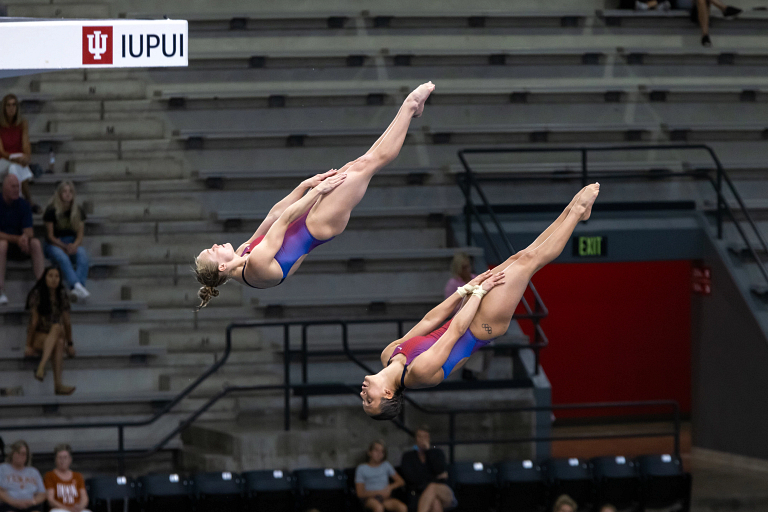Two divers twisting through the air