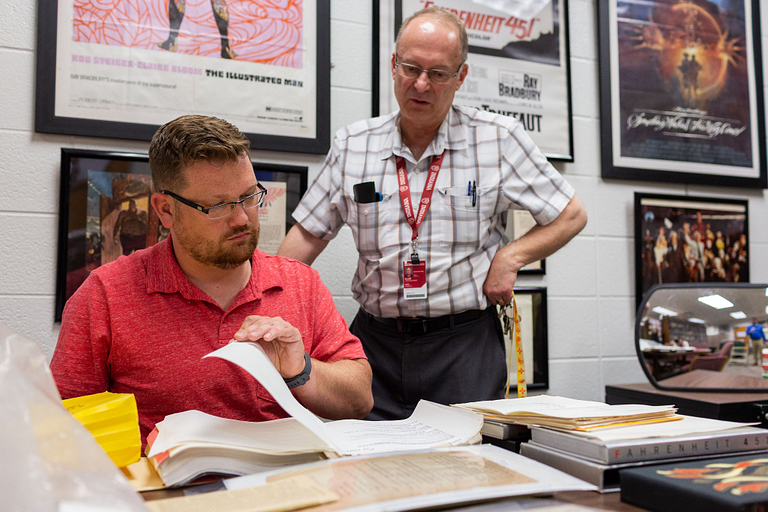 Jason Aukerman and Jon Eller examine pages from a script.