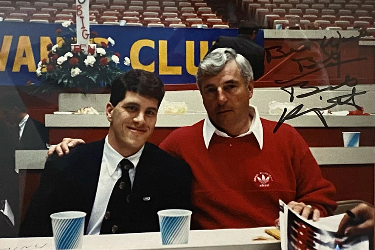 Harper and Bob Knight sit at a table, the image is autographed 
