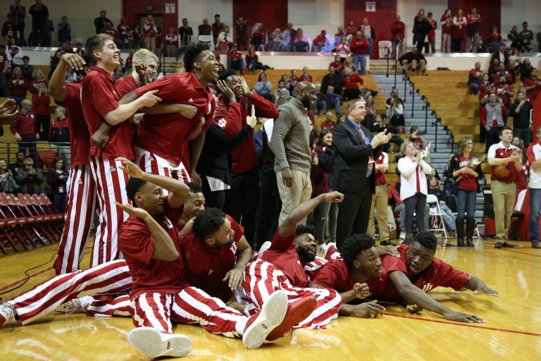 Collin Hartman's teammates react to Hartman's proposal by laying on the floor, yelling and pointing.