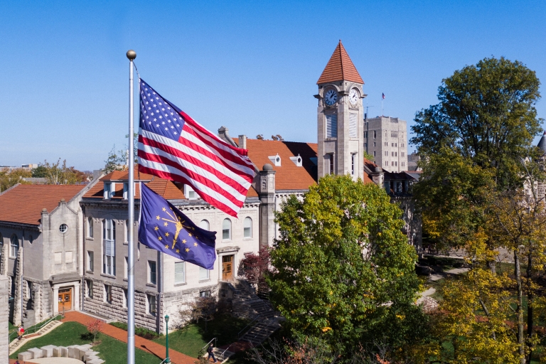 An American flag and the Indiana state flag flies over the Student Building