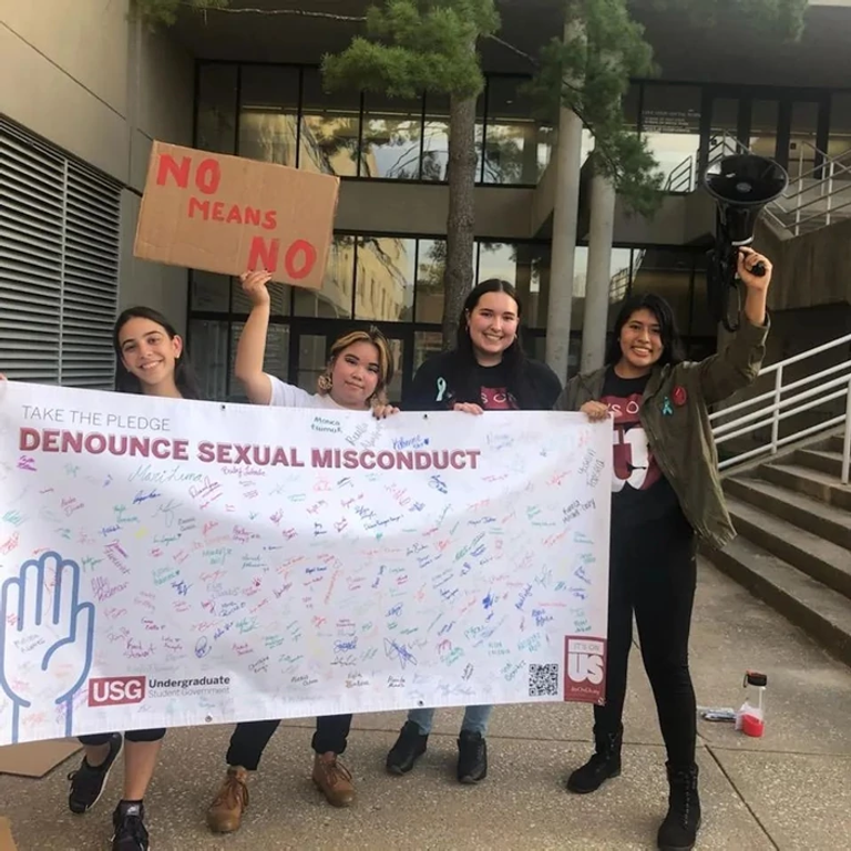students holding banner and sign