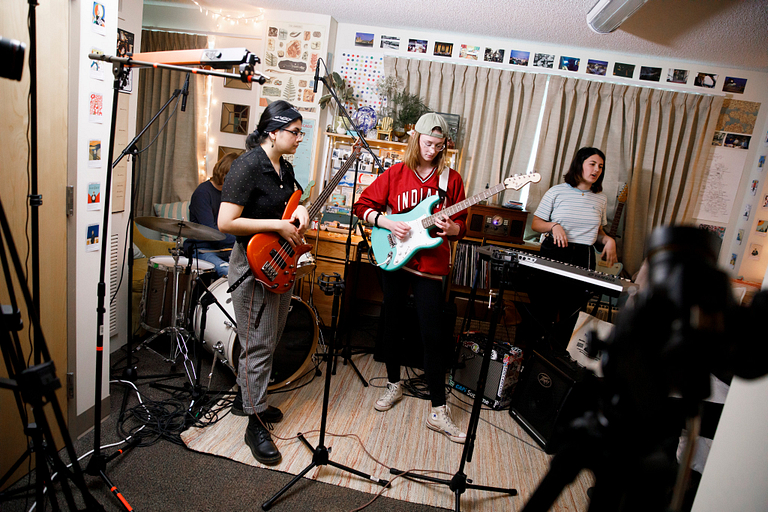 A tiny dorm concert being filmed. 