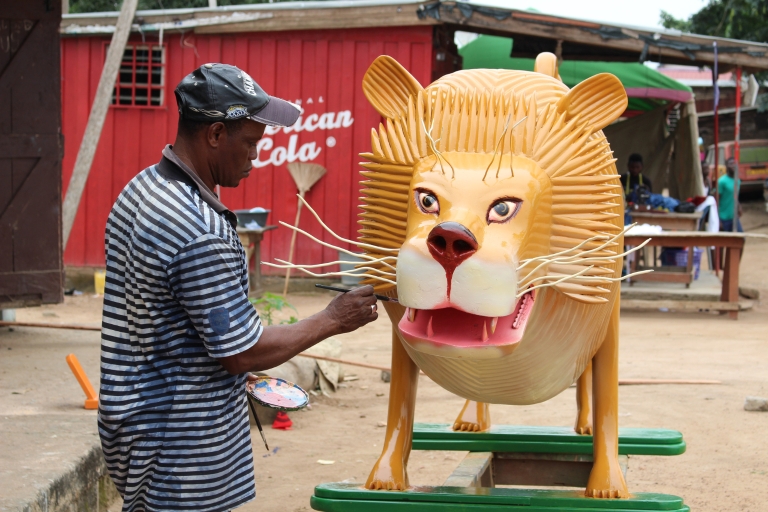 Daniel Anum Jasper paints details on a lion figure.