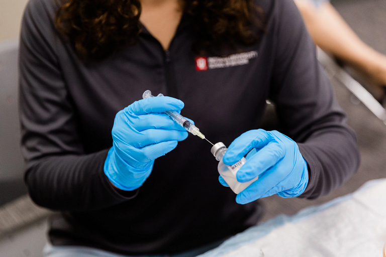 A woman practicing giving a COVID-19 vaccine