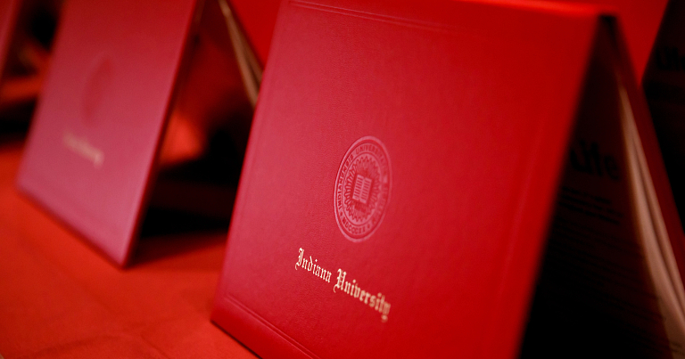 A row of red IU diploma covers 