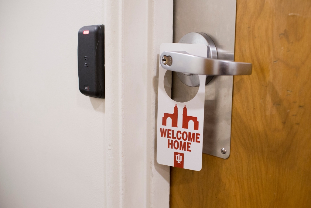 A sign that says welcome home hangs on a door handle