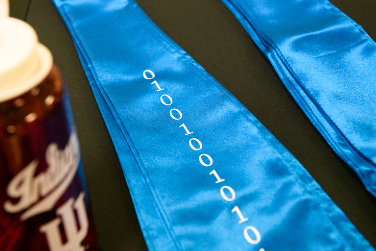 Blue honor stoles with zeroes and ones printed on them