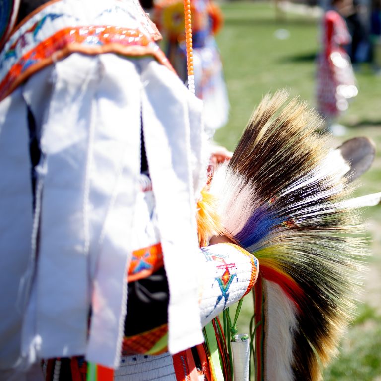 A man holds a headdress at IU's powwow