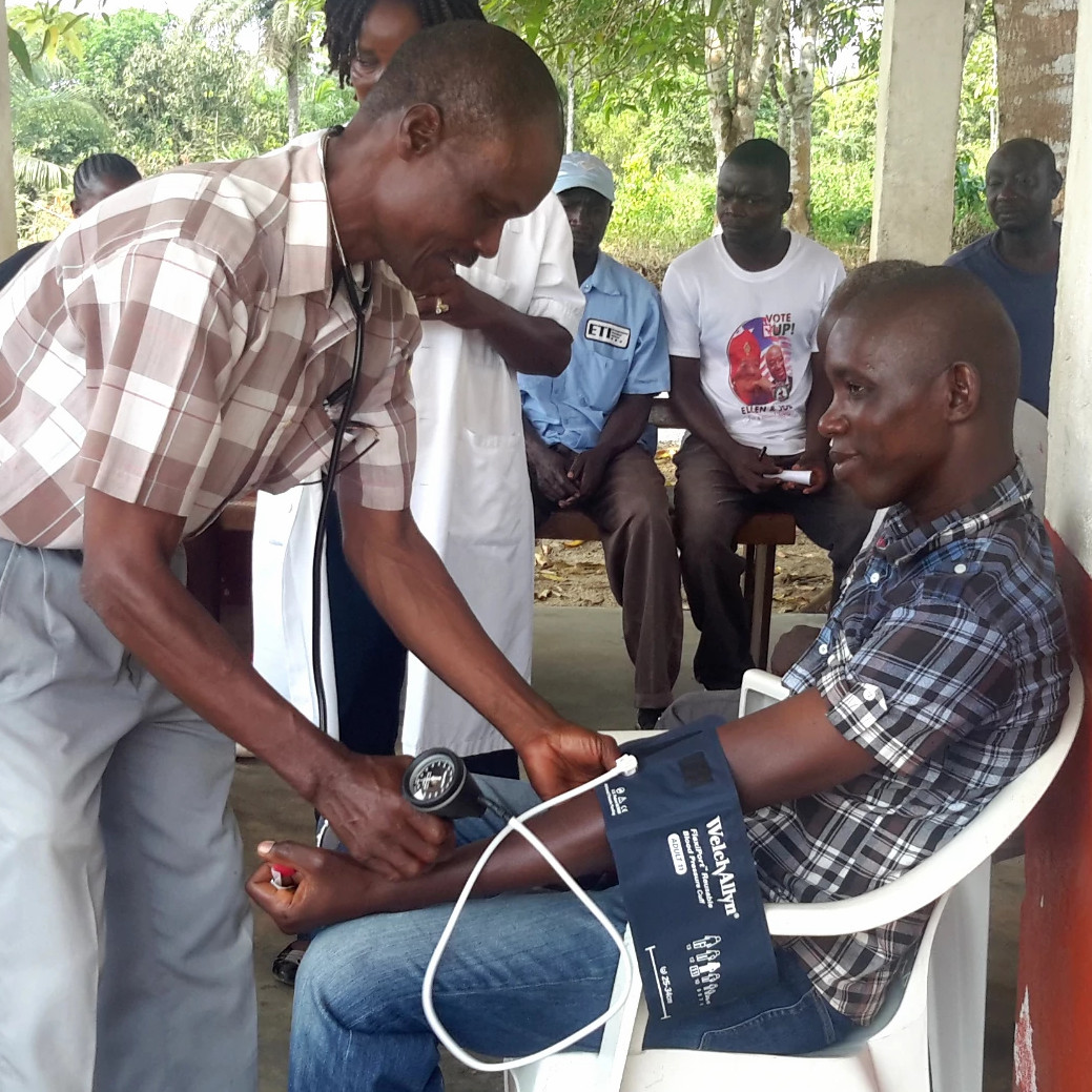 A Liberian man learns to take another man's blood pressure