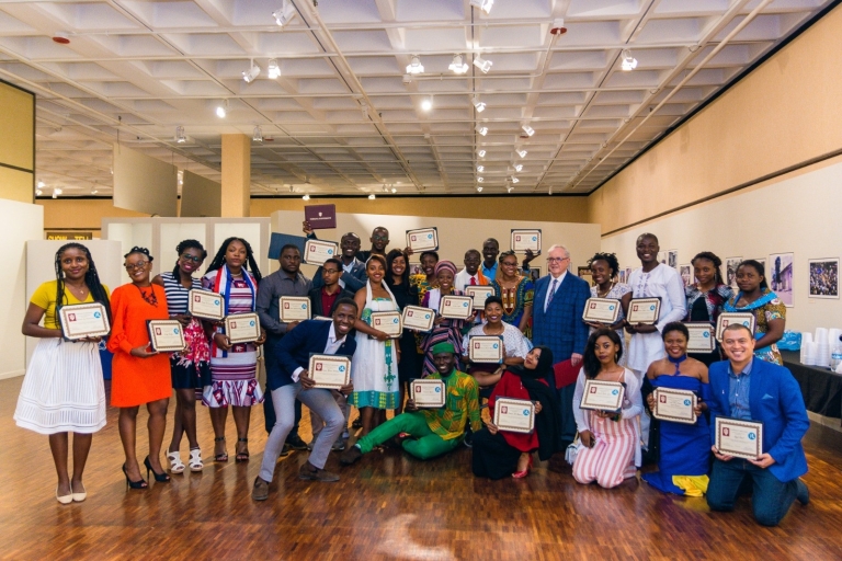 Mandela Washington fellows stand in a large room holding their certificates