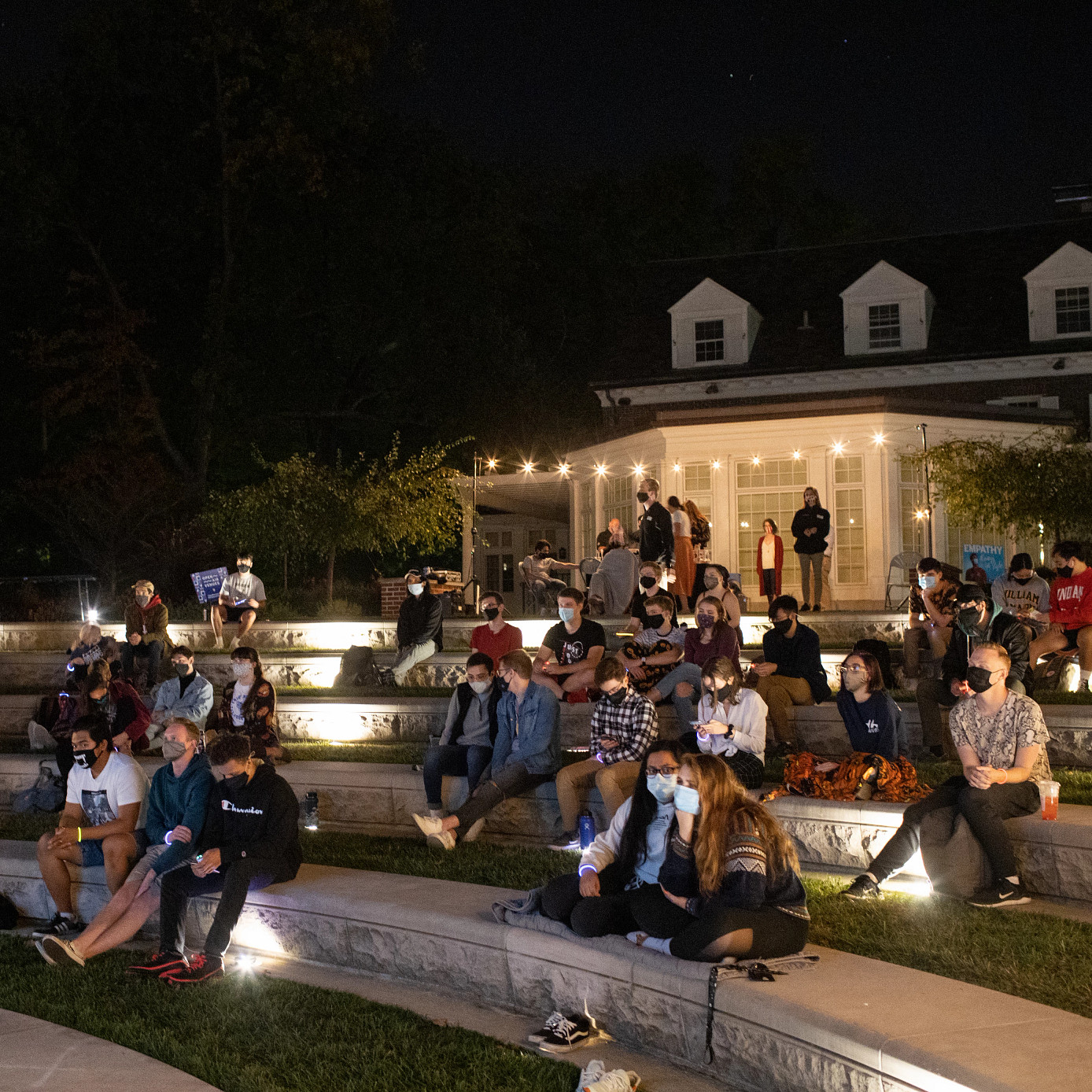 Group of students watches debate in outdoor amphitheater