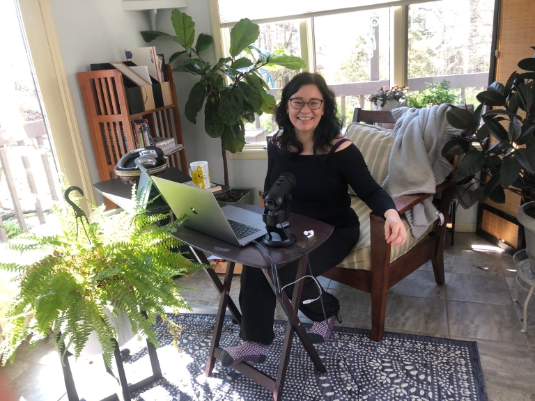 Erika Lee sits in a chair at a table in her home workspace