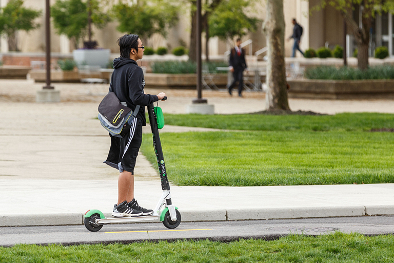 A student on a scooter on campus 