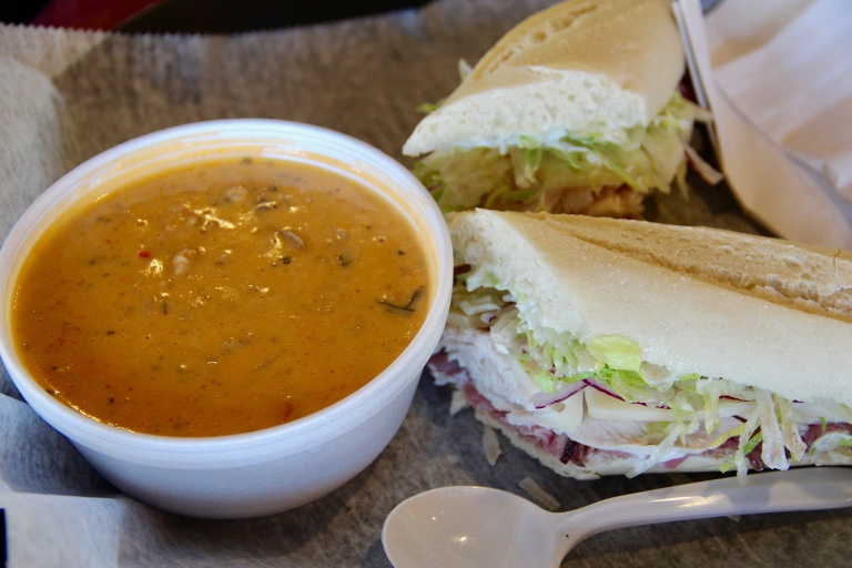 Soup and a sandwich are ready to eat.