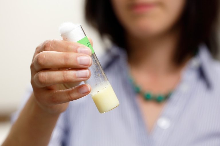 Irene Newton holds a vial with fruit flies