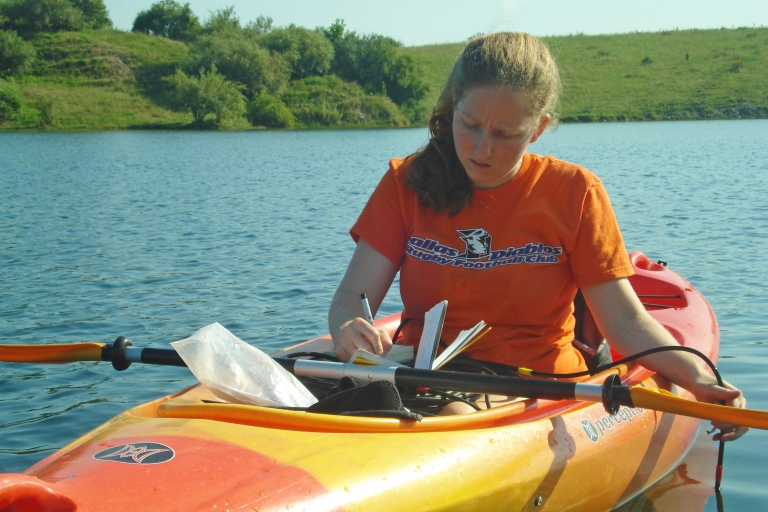 Marta Shocket paddles a kayak in a lake