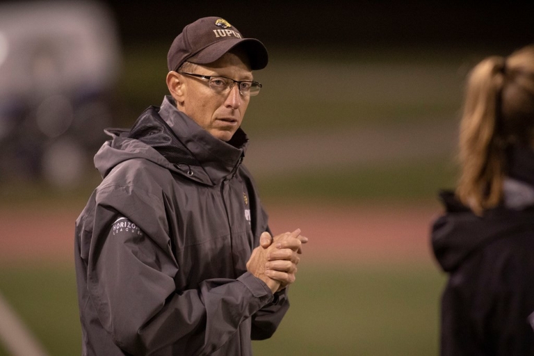 women's soccer coach Chris Johnson watches his team during a game