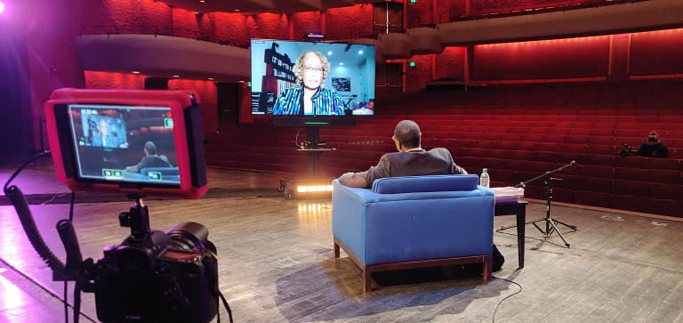 Man interviews woman through flat-screen tv