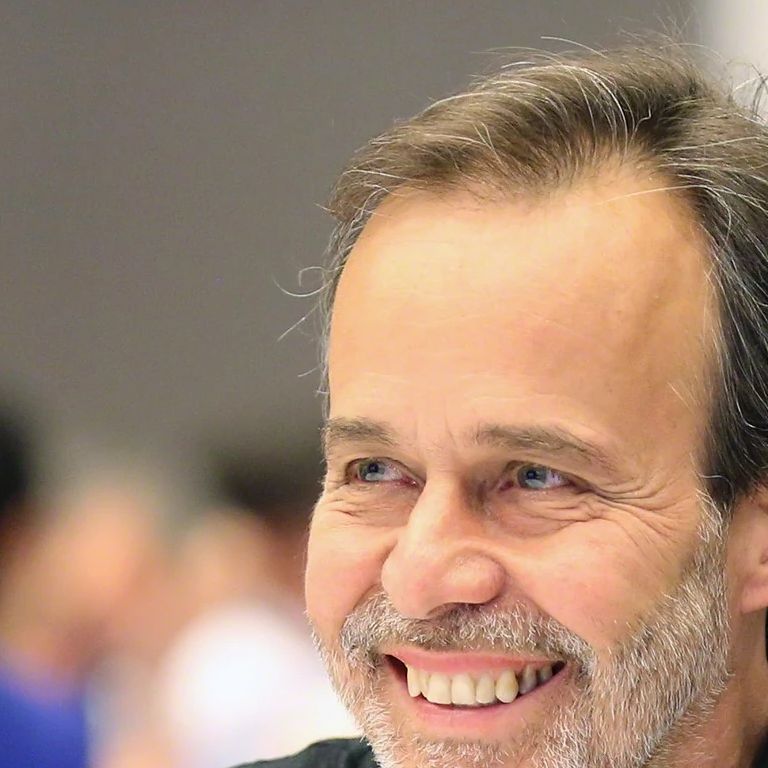 Eduardo S. Brondizio smiles while sitting at a table.