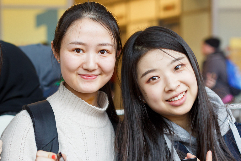 Two female students smile for the camera
