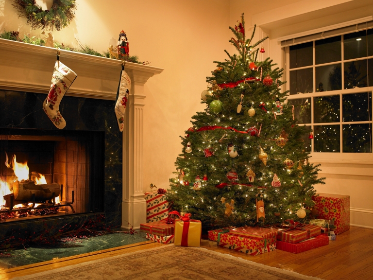 Wrapped gifts and a decorated Christmas tree near a fireplace