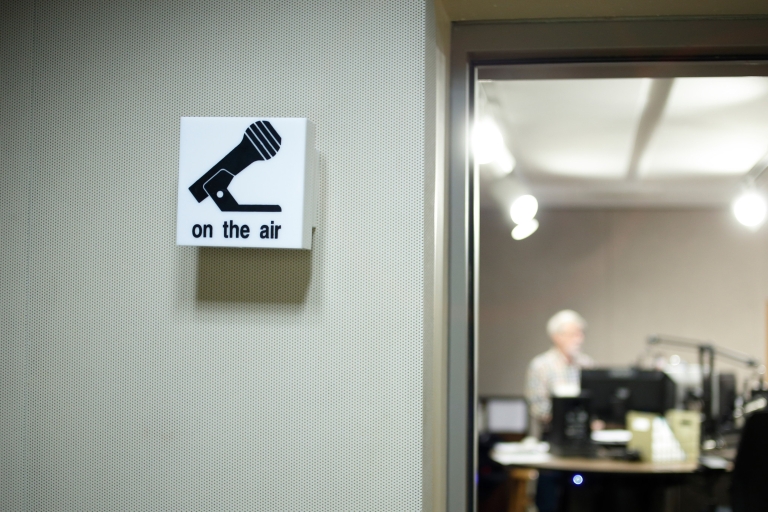 A sign with a microphone that says 'on the air'