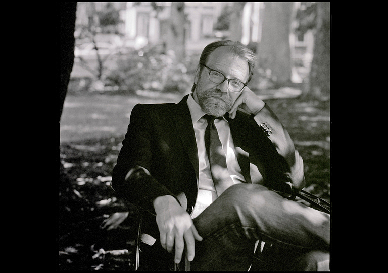 George Saunders sitting outside on a bench
