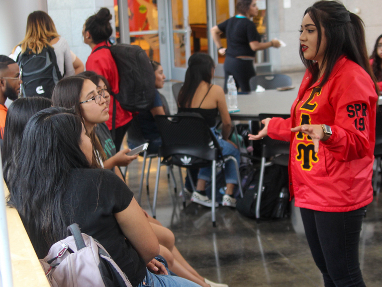 Yoriana speaks with a group of students.