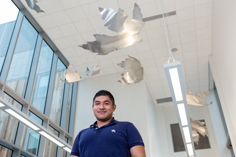 JesÃºs Nava stands under his artwork.