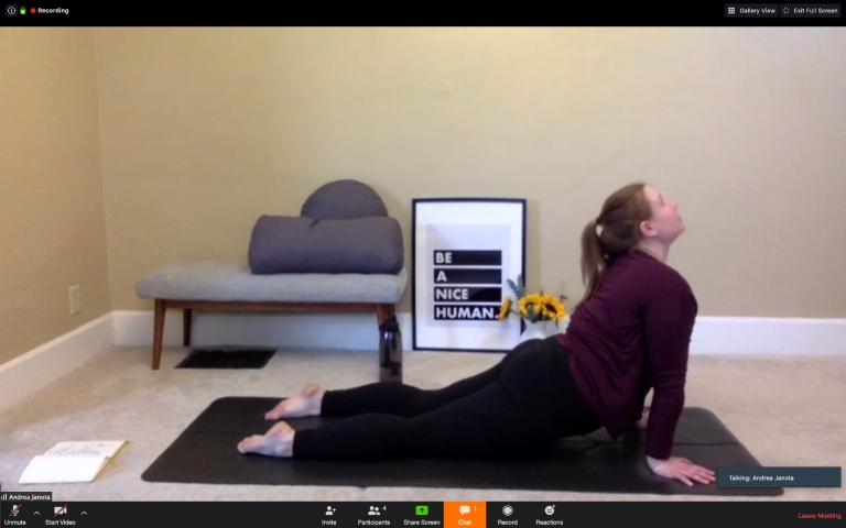 a woman teaches yoga virtually on a video conference
