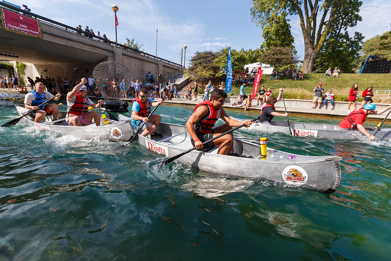 Three teams are racing in canoes on the canal